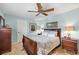 Bedroom with a wood bed, patterned bedding, a ceiling fan and a window providing plenty of natural light at 5507 Country Lakes Trl, Sarasota, FL 34243