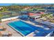 Relaxing community pool area featuring lounge chairs, tables, and tennis courts at 5507 Country Lakes Trl, Sarasota, FL 34243