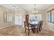 Bright dining room with chandelier, neutral walls, and large windows at 5507 Country Lakes Trl, Sarasota, FL 34243