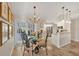 Bright dining area featuring a modern chandelier, decorative artwork, and sliding glass doors leading to the patio at 5507 Country Lakes Trl, Sarasota, FL 34243