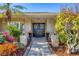 Charming home entrance with double doors, decorative wreaths, and meticulously landscaped walkway at 5507 Country Lakes Trl, Sarasota, FL 34243