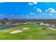 Beautiful golf course view featuring lush greenery, water features, sand traps and picturesque landscaping under a sunny sky at 5507 Country Lakes Trl, Sarasota, FL 34243