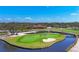 Scenic golf course view showcasing manicured greens, water features, and a clubhouse under a bright, clear sky at 5507 Country Lakes Trl, Sarasota, FL 34243