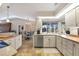 Well-lit kitchen with white cabinetry, stainless steel appliances, and a view of the dining area at 5507 Country Lakes Trl, Sarasota, FL 34243