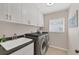 Laundry room with gray front load washer and dryer and lots of counter and cabinet space at 5507 Country Lakes Trl, Sarasota, FL 34243