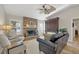 Cozy living room with a brick fireplace, comfortable seating, and a decorative ceiling fan at 5507 Country Lakes Trl, Sarasota, FL 34243