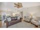 Spacious living room with comfortable furniture, view of the dining area, and a decorative ceiling fan at 5507 Country Lakes Trl, Sarasota, FL 34243