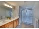 Bathroom featuring double sinks, a large mirror, and walk-in shower at 6063 Benevento Dr, Sarasota, FL 34238