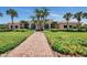 Expansive clubhouse entrance with manicured lawn and brick path, highlighting the building's architecture and landscaping at 6063 Benevento Dr, Sarasota, FL 34238