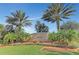 Landscaped entrance to The Isles of Palmer Ranch, featuring a prominent sign and mature palm trees against a clear blue sky at 6063 Benevento Dr, Sarasota, FL 34238