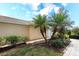 Landscaped front yard with palm trees and brick walkway leading to the front door at 6063 Benevento Dr, Sarasota, FL 34238