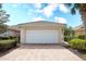 Two-car garage with a brick paver driveway and well-maintained landscaping at 6063 Benevento Dr, Sarasota, FL 34238