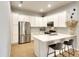 Modern kitchen with white cabinets, stainless steel appliances, and breakfast bar at 6063 Benevento Dr, Sarasota, FL 34238