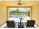 Relaxing enclosed patio view of the pool and pond, featuring comfortable seating and a ceiling fan at 6063 Benevento Dr, Sarasota, FL 34238