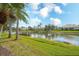 Scenic view of a peaceful pond surrounded by well-maintained lawns and mature trees at 6063 Benevento Dr, Sarasota, FL 34238