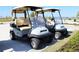 Two Club Car golf carts parked in a lot at 6086 Worsham Ln # 102, Bradenton, FL 34211