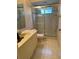 Bathroom with beige tile flooring and a shower with glass doors at 611 Cedars Ct, Longboat Key, FL 34228