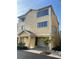 Three-story building with attached garage, featuring a light yellow exterior and a palm tree in the front at 611 Cedars Ct, Longboat Key, FL 34228