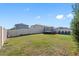 Fenced backyard featuring lush green grass, trampoline, and chairs provides ample space for outdoor enjoyment at 6218 Apple Snail Ave, New Port Richey, FL 34653