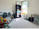 Bedroom featuring a drum set, bookshelf, and natural light from the window, perfect for a hobby space at 6218 Apple Snail Ave, New Port Richey, FL 34653