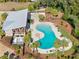 Aerial view of a community pool and lounge area with palm trees, landscaping, and grilling stations at 6218 Apple Snail Ave, New Port Richey, FL 34653