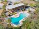 Aerial view of a modern community pool with a covered lounge area surrounded by lush landscaping at 6218 Apple Snail Ave, New Port Richey, FL 34653