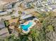 Overhead view of a community pool with a unique shape, complemented by lounge area and landscaping at 6218 Apple Snail Ave, New Port Richey, FL 34653