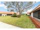 View of backyard with large tree and green grass at 6666 Draw Ln # 132, Sarasota, FL 34238