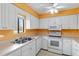 Kitchen with white cabinets, stainless steel appliances and orange walls at 6666 Draw Ln # 132, Sarasota, FL 34238