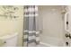 Clean bathroom featuring a tub and shower with grab bars and a striped curtain for privacy at 6939 W Country Club N Dr # 158, Sarasota, FL 34243