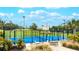 Bright blue pickleball court with black fencing, tables and chairs and lush landscaping is the perfect place to relax and unwind at 6939 W Country Club N Dr # 158, Sarasota, FL 34243