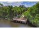 Aerial view of a lakefront property with a wooden dock and lush landscaping at 6978 Superior Street Cir, Sarasota, FL 34243