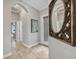 Inviting hallway features neutral paint, tile flooring, arched ceilings, and decorative mirror at 8729 52Nd E Dr, Bradenton, FL 34211