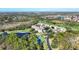 Aerial view of the community's condos, pool, and tennis courts surrounded by greenery at 8755 Olde Hickory Ave # 7302, Sarasota, FL 34238