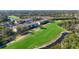 Scenic view of community buildings overlooking the lush green golf course and pond at 8755 Olde Hickory Ave # 7302, Sarasota, FL 34238