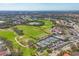 Aerial view of a lush golf course, clubhouse, pool, tennis courts, and surrounding residential community at 8755 Olde Hickory Ave # 7302, Sarasota, FL 34238