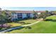 Manicured grounds with lush green grass, walkway, and condo buildings in the background at 8755 Olde Hickory Ave # 7302, Sarasota, FL 34238