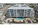 Expansive aerial view of a modern condo building by the beach with pool, hot tub, and beautiful landscaping at 1035 Seaside Dr # 503, Sarasota, FL 34242