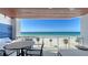 Expansive balcony with ocean view, featuring a lounge area, a dining table, and a grill at 1035 Seaside Dr # 503, Sarasota, FL 34242