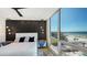 Bright primary bedroom featuring stylish side tables, accent wall, and ocean views at 1035 Seaside Dr # 503, Sarasota, FL 34242