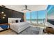 Bright primary bedroom with a striking accent wall, stylish lighting, and ocean views at 1035 Seaside Dr # 503, Sarasota, FL 34242