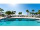 Beautiful pool area with a beach view and lovely green palm trees at 1035 Seaside Dr # 503, Sarasota, FL 34242