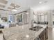 Granite countertop island with stainless sink overlooking living and dining spaces at 13922 Old Creek Ct, Parrish, FL 34219