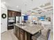 Granite kitchen island with stainless sink and seating overlooks the living room area at 13922 Old Creek Ct, Parrish, FL 34219