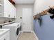 Functional laundry room with white cabinets, modern appliances, and stylish décor at 13922 Old Creek Ct, Parrish, FL 34219