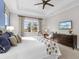 Well-lit bedroom with blue accent wall, large window, and tray ceiling at 13922 Old Creek Ct, Parrish, FL 34219