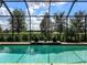 Sparkling screened pool offers a relaxing oasis with beautiful views of lush greenery and blue skies at 13922 Old Creek Ct, Parrish, FL 34219