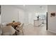 Bright dining area features a modern table with four chairs, seamlessly connected to the kitchen with white cabinets at 14180 Crimson Ave, Bradenton, FL 34211