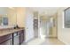 Bathroom featuring granite counters, brown cabinetry, and a large shower with a glass door at 14318 Fissore Blvd, Wimauma, FL 33598