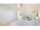 Bright bedroom featuring a ceiling fan, closet and a full-length mirror near a white bed at 14318 Fissore Blvd, Wimauma, FL 33598